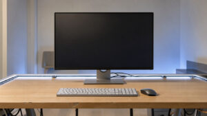 Bureau high-tech ergonomique et lumineux avec écran vierge, clavier minimaliste, câbles soigneusement rangés et ambiance moderne apaisante.