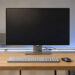 Bureau high-tech ergonomique et lumineux avec écran vierge, clavier minimaliste, câbles soigneusement rangés et ambiance moderne apaisante.